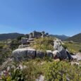 Ancient stone ruins surrounded by mountains and wild vegetation in Zarakas
