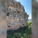 Original frame from the MOURIES Instagram Reel showing the ancient walls of Zarax above Gerakas