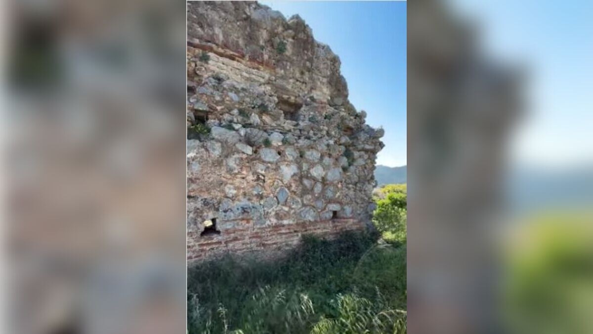 Original frame from the MOURIES Instagram Reel showing the ancient walls of Zarax above Gerakas